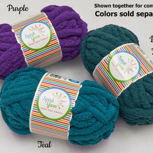 May include: Three skeins of yarn in purple and teal colors. The yarn is soft and fluffy, and it is perfect for crocheting or knitting. The yarn is labeled "Spirit Yarn" and "Show Your Colors!"
