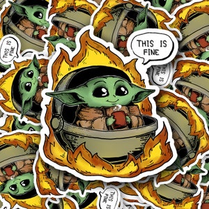 Op de afbeelding: Een sticker met een cartoonfiguur, een groen baby-achtig buitenaards wezen, zittend in een pod die door vlammen wordt verzwolgen. Het personage houdt een rode mok vast met stoom die eruit komt. De sticker heeft een spraakballon met de tekst "This is fine".