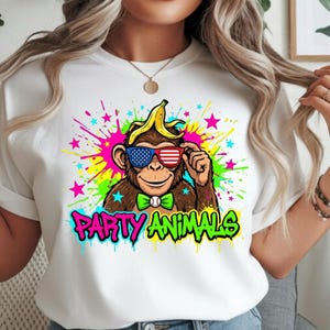 May include: White t-shirt featuring a cartoon monkey with a banana on its head and sunglasses with an American flag design. The monkey wears a green bow tie and is set against a colorful splatter background with the words "PARTY ANIMALS".