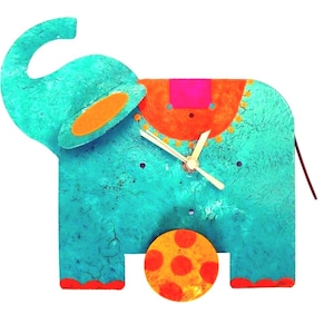 May include: A turquoise blue elephant clock with orange and pink accents. The clock has a gold-coloured face with black hands and a red and orange polka dot ball at the bottom.