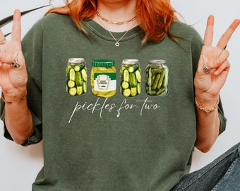 May include: A green t-shirt with a graphic of four pickle jars and the text "pickles for two".
