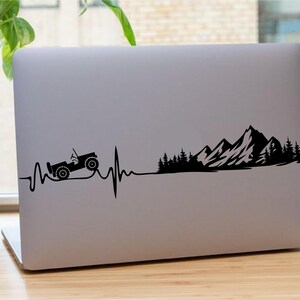 May include: Black and white silhouette of a jeep driving over a mountain range with a heartbeat line. The mountains are in the background and the jeep is in the foreground.