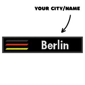 May include: Black and white embroidered patch with the German flag colors and the word "Berlin" in white text.