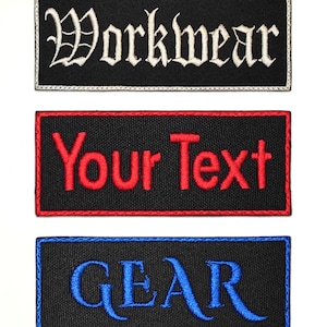 Op de afbeelding: Drie rechthoekige geborduurde patches. De bovenste patch is zwart met het woord "Workwear" in witte gotische letters. De middelste patch is zwart met "Your Text" in rood. De onderste patch is zwart met "GEAR" in blauw.