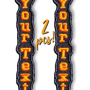 May include: Two embroidered patches with the words "YOUR TEXT" in orange letters on a black background. The patches are vertical and have a decorative border. The number "2" and the word "pcs!" are in orange.
