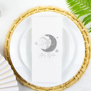 Könnte beinhalten: Eine rechteckige weiße Karte mit einer grauen Grafik eines Halbmondes, der eine Widder-Illustration enthält, umgeben von kleinen Sternen und Herzen. Unter dem Mond ist der Text Aries Studio in einer grauen Schreibschrift aufgedruckt.
