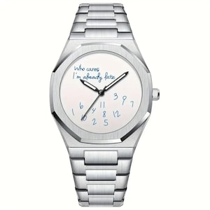 Pode incluir: Um relógio de pulso prateado com mostrador branco e pulseira de metal a condizer. O mostrador do relógio apresenta números manuscritos azuis e a frase "Who cares I'm already late". O relógio tem um design geométrico.