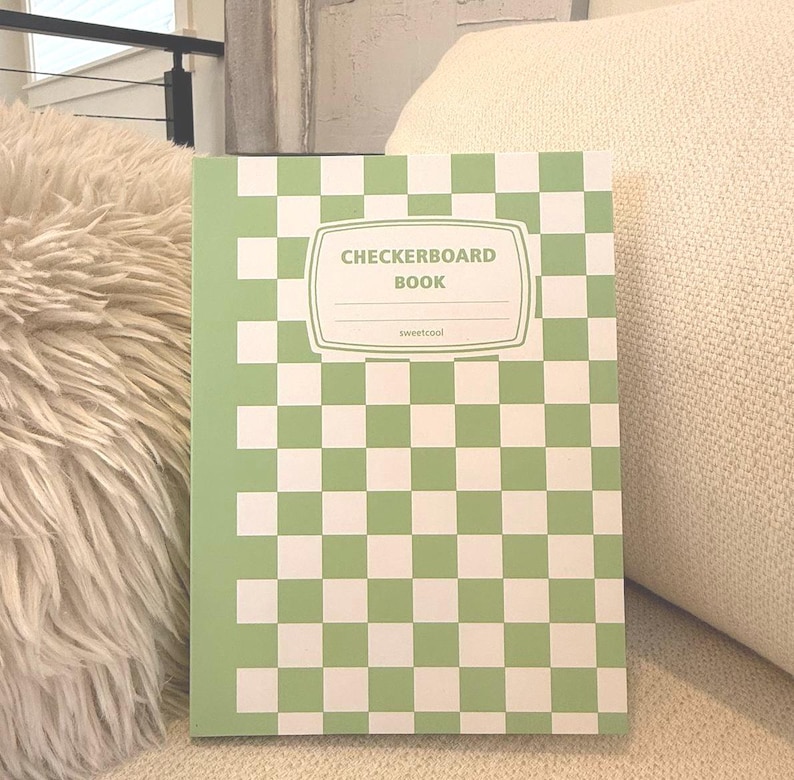May include: A green and white checkered notebook with the text "Checkerboard Book" and "sweetcool" on the front cover.