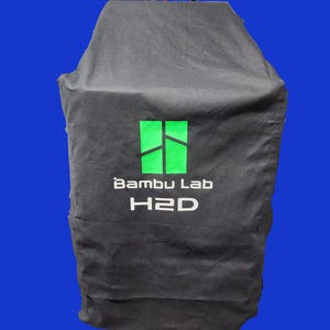 May include: Black fabric cover with a green logo that says "Bambu Lab H2D".