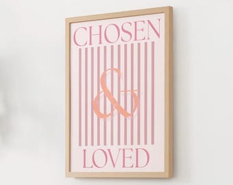 Può includere: Stampa incorniciata con le parole "CHOSEN & LOVED" in rosa. Lo sfondo presenta strisce rosa verticali. La & è color corallo. La cornice è color legno chiaro.