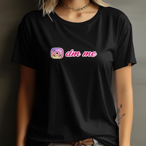 May include: Black t-shirt with a pink "dm me" text and an Instagram camera icon.