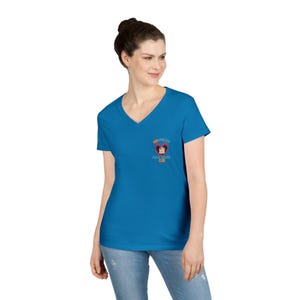 May include: A vibrant blue V-neck t-shirt featuring a small, colorful graphic on the chest. The graphic includes text and a stylized design. The shirt is made of a soft material and is suitable for casual wear.