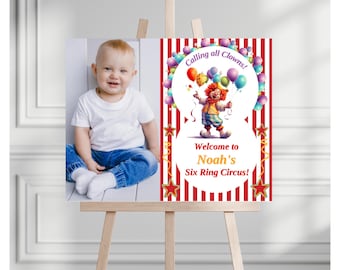 May include: A red and white striped sign with a clown holding balloons and the text "Calling all Clowns! Welcome to Noah's Six Ring Circus!" A photo of a baby boy is in the corner of the sign.