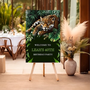 May include: Welcome to Leah's 40th Birthday Party sign with a green jungle background and a jaguar lying on leaves.