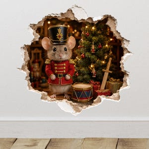 May include: A wall decal featuring a mouse dressed as a toy soldier in a red uniform with gold trim and a black hat. The mouse stands next to a small drum, a wooden sword, and a decorated Christmas tree with lights, all within a hole in the wall.