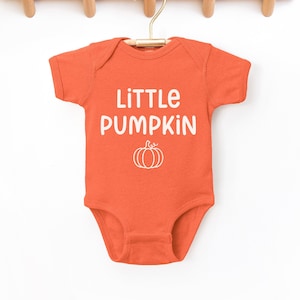 May include: Orange baby onesie with white text that reads "Little Pumpkin" and a small white pumpkin graphic.