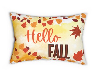 May include: A yellow and orange throw pillow with a watercolor background and scattered autumn leaves. The pillow has the text "Hello Fall" in orange and brown lettering.