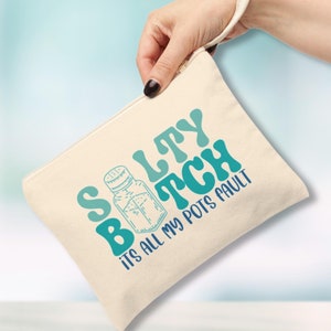 May include: A beige canvas pouch with a blue and green design that says "Salty Bitch It's All My Pots Fault". The pouch has a zipper closure and a handle.