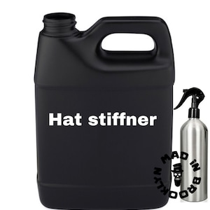 May include: Black plastic hat stiffener in a large jug with a handle, and a silver spray bottle. The text "Hat stiffner" is printed in white on the jug. The spray bottle has a black nozzle and the words "MAD IN BROOKLYN" are printed on the bottle.
