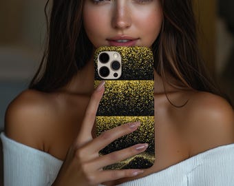 Puede incluir: Funda de teléfono con purpurina negra y dorada. La funda tiene un fondo negro con tres franjas horizontales de purpurina dorada. La funda del teléfono tiene un módulo de cámara y flash.