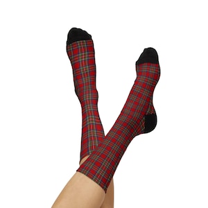 Puede incluir: Un par de calcetines de media caña con un patrón de cuadros escoceses en rojo, azul y verde. Los calcetines tienen tela negra sólida en las secciones de la puntera y el talón, creando un contraste marcado con el diseño colorido del cuerpo.