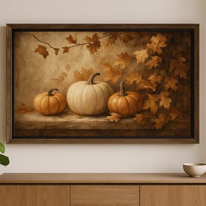 May include: A framed painting featuring three pumpkins in shades of orange and white, set against a backdrop of autumn leaves. The artwork evokes a warm, seasonal ambiance, perfect for fall decor.