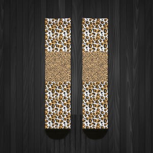 May include: A pair of socks with a leopard print design. The socks are brown, white, and black. The socks are made of a soft, comfortable material.