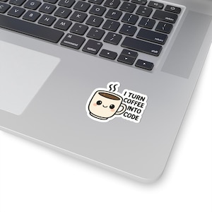 May include: A white sticker with a cartoon coffee cup design, complete with a smiling face and steam. The sticker includes the text "I TURN COFFEE INTO CODE" in black lettering.