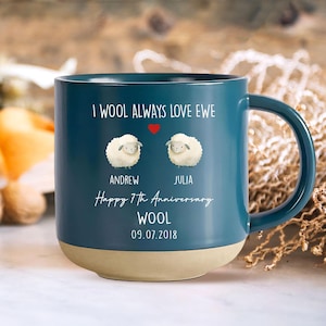 May include: A blue ceramic mug with a white sheep design and the text "I wool always love ewe". The mug also has the text "Happy 7th Anniversary Wool 09.07.2018" and the names "Andrew" and "Julia".