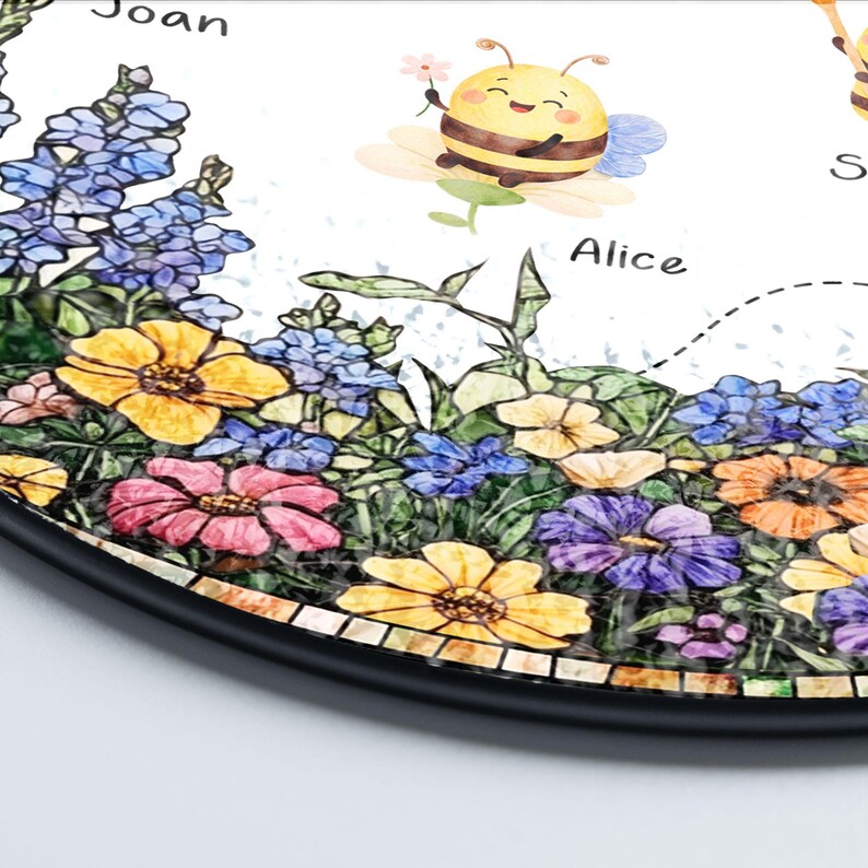 May include: A round decorative item featuring a colorful floral design with yellow, pink, and purple flowers. A cartoon bee is perched on a flower. The names "Joan" and "Alice" are written on the item.