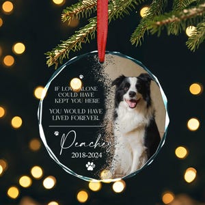 May include: A glass Christmas bauble featuring a black and white border collie dog photo. The bauble has the text "IF LOVE ALONE COULD HAVE KEPT YOU HERE YOU WOULD HAVE LIVED FOREVER." and "Peaches 2018-2024".
