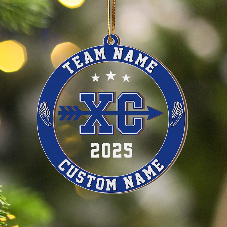 Puede incluir: Adorno redondo, azul y transparente, con los textos blancos &laquo;&nbsp;TEAM NAME&nbsp;&raquo; y &laquo;&nbsp;CUSTOM NAME&nbsp;&raquo;. El centro presenta &laquo;&nbsp;XC&nbsp;&raquo; con una flecha, el a&ntilde;o &laquo;&nbsp;2025&nbsp;&raquo; y gr&aacute;ficos de alas. Una cuerda dorada est&aacute; unida para colgar.