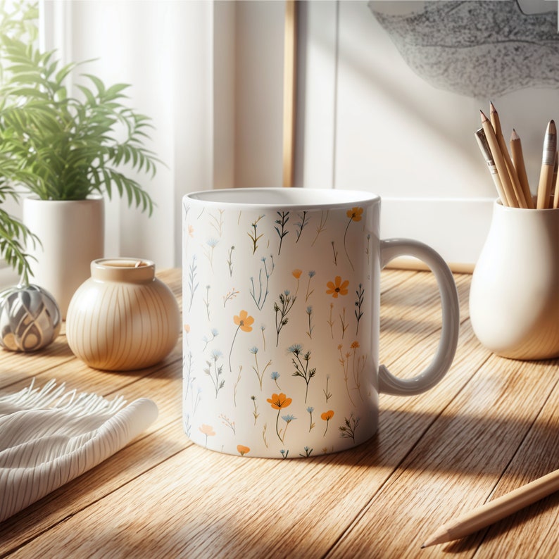 A mug with a dainty floral design with blue, yellow, and white flowers. The main color of the mug is white on the inside and outside.