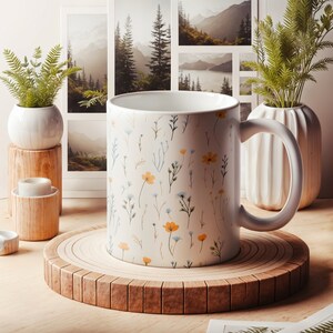A mug with a dainty floral design with blue, yellow, and white flowers. The main color of the mug is white on the inside and outside.