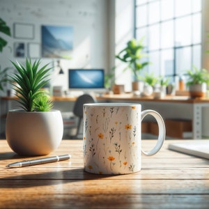 A mug with a dainty floral design with blue, yellow, and white flowers. The main color of the mug is white on the inside and outside.