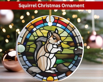May include: A round ceramic Christmas ornament featuring a stained glass design of a squirrel holding a nut. The squirrel is brown and white with a long bushy tail. The stained glass design is colorful with shades of blue, green, yellow, red, and orange.