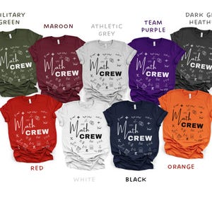 May include: A collection of t-shirts in various colors, including military green, maroon, athletic grey, team purple, dark grey heather, red, white, black, and orange. Each shirt features the text "Math Crew" with math symbols.