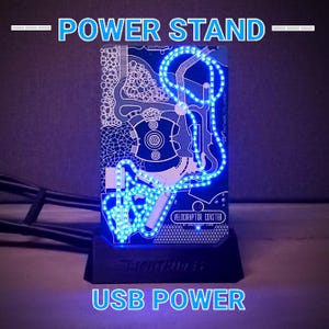 May include: A blue LED light-up stand with a circuit board design featuring a roller coaster track. The stand is powered by USB and has the text "VELOCIRAPTOR COASTER" printed on it.