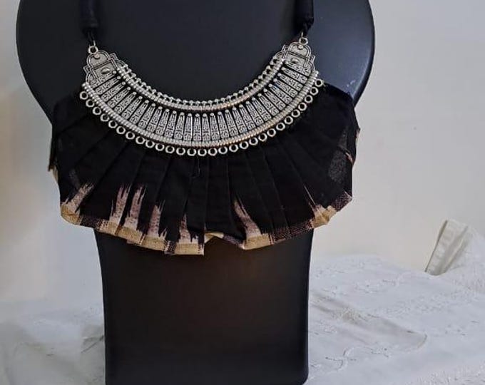 Exclusive necklace with silver oxidised big oval pendant with fabric fringes and matching earrings.