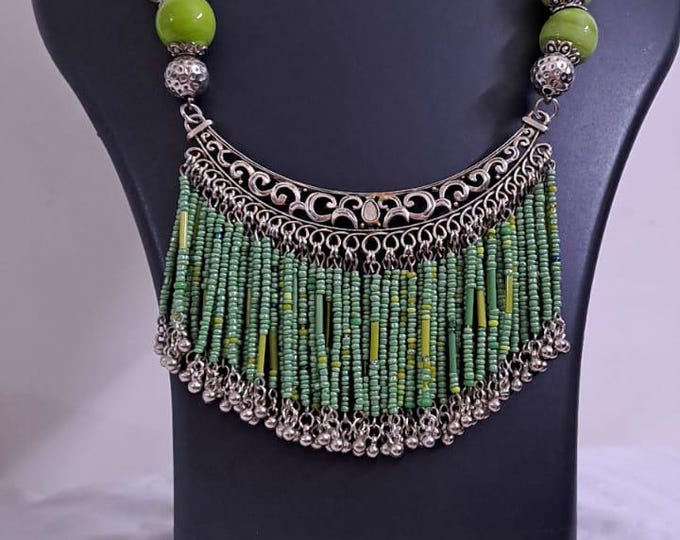 Exclusive necklace with silver oxidised big oval pendant with seed beads fringes and matching earrings.