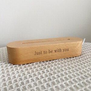 May include: A wooden phone stand with a slot for charging cables. The stand is engraved with the text "Just to be with you".
