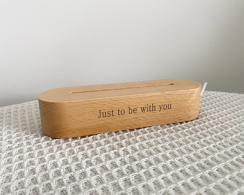 May include: A wooden phone stand with a slot for charging cables. The stand is engraved with the text "Just to be with you".