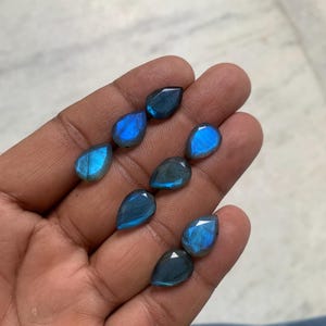 May include: Seven pear-shaped labradorite gemstones in various shades of blue with iridescent flashes.