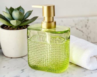 Zeepdispenser van groen glas: modern badkamerdecor met gouden pompje
