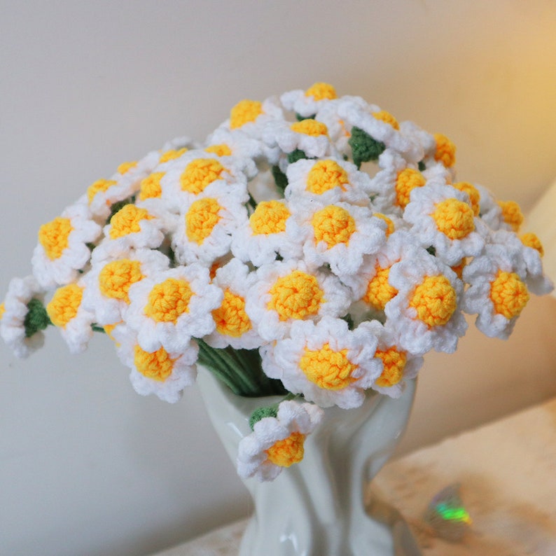 Knitted daisies. The rhizome is green, the petals are white, and the center of the flower is yellow