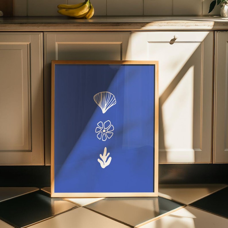 May include: A framed print with a blue background and three white stylized illustrations of a leaf, a flower, and a fan.