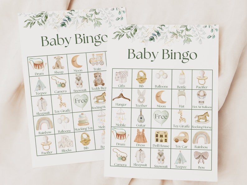 May include: Two printable baby bingo cards with a green floral border. The cards feature illustrations of baby items such as a pacifier, a rattle, a rocking horse, a teddy bear, a teepee, a camera, a snowsuit, a hat, a bottle, a bib, a dress, a dollhouse, a toy car, a rainbow, a drum, a guitar, a mobile, a moon, a stacking toy, a toy giraffe, a pair of blocks, a bib, a bow, and a pair of shoes. The cards are free to download and print.