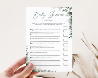 May include: A printable baby shower game card with a green leafy design. The card has the title "Baby Shower Family Feud" and asks players to guess the top answers to questions based on a survey of people.
