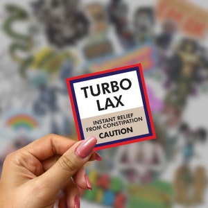 以下が含まれることがあります： 白文字で「TURBO LAX」と書かれた赤と青のステッカー。ステッカーには黒文字で「INSTANT RELIEF FROM CONSTIPATION CAUTION」の文字も書かれている。
