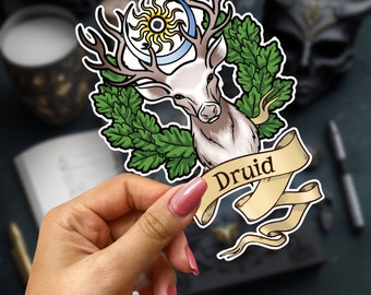 May include: A sticker featuring a white deer with antlers, a crescent moon and sun, and a green oak leaf wreath. The sticker has a banner with the word "Druid" written on it.